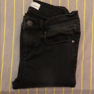Black skinny jeans with frayed ends.